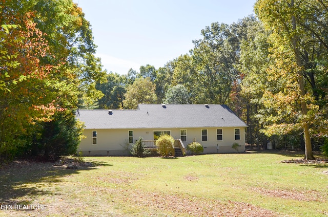 rear view of property featuring a yard and a deck