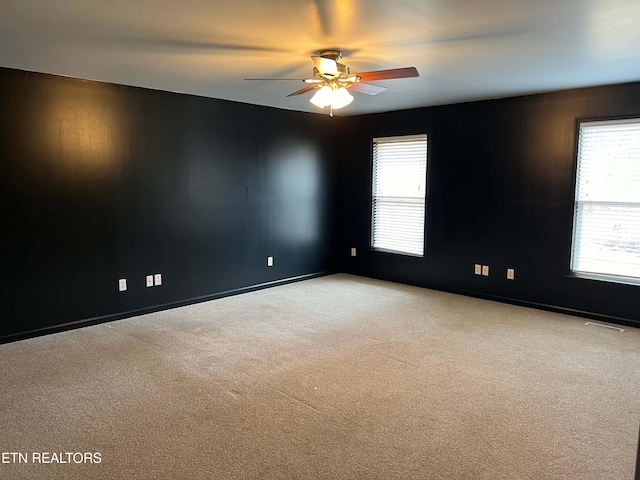 spare room with ceiling fan and light colored carpet