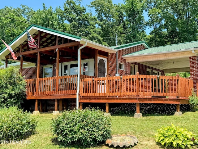 back of house featuring a wooden deck and a lawn