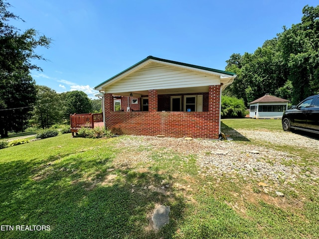 view of side of home featuring a deck and a lawn