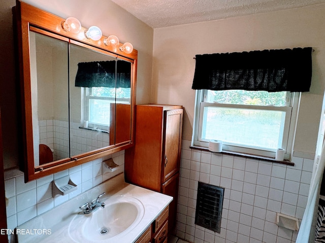 bathroom featuring tile walls, heating unit, a textured ceiling, and vanity