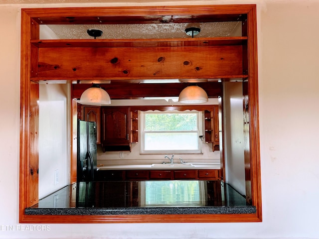 kitchen with sink and black fridge with ice dispenser