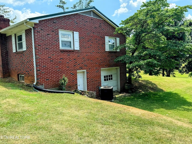 view of side of home featuring a garage, central AC unit, and a lawn