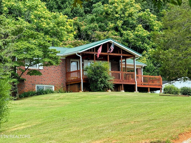 exterior space featuring a front yard and a wooden deck