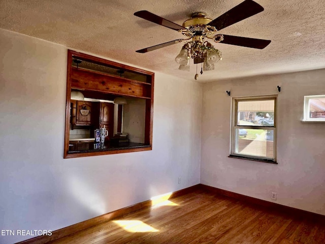 spare room with hardwood / wood-style flooring, a textured ceiling, and ceiling fan