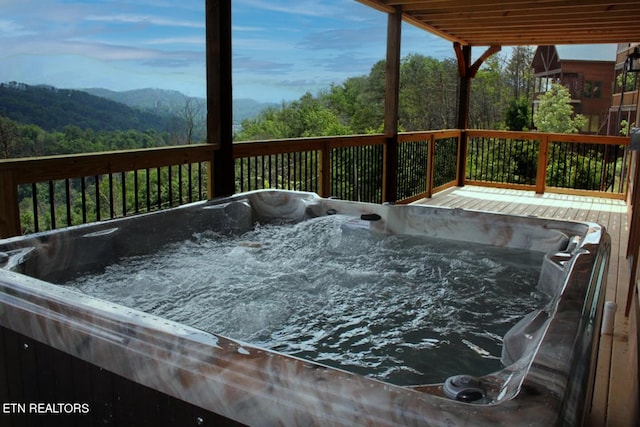 wooden deck featuring a hot tub