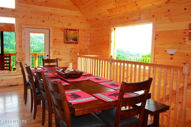 dining space with wood-type flooring and vaulted ceiling