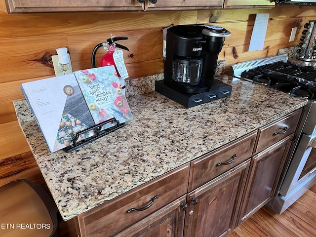 interior details featuring gas range oven and wooden walls