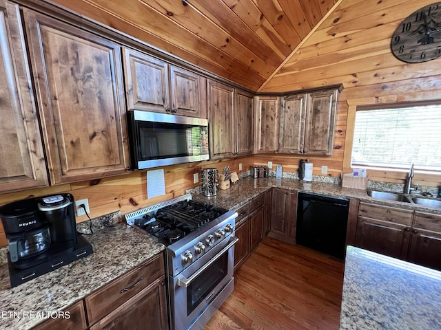 kitchen with gas stove, wooden walls, light hardwood / wood-style flooring, vaulted ceiling, and dishwasher