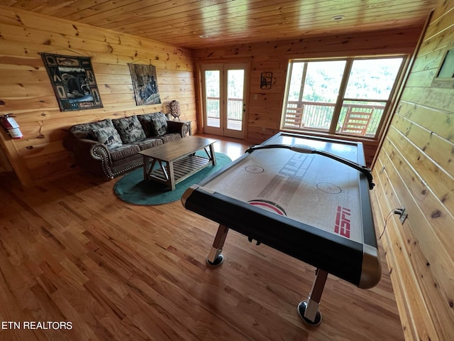 rec room with wood ceiling, wood walls, wood-type flooring, and french doors