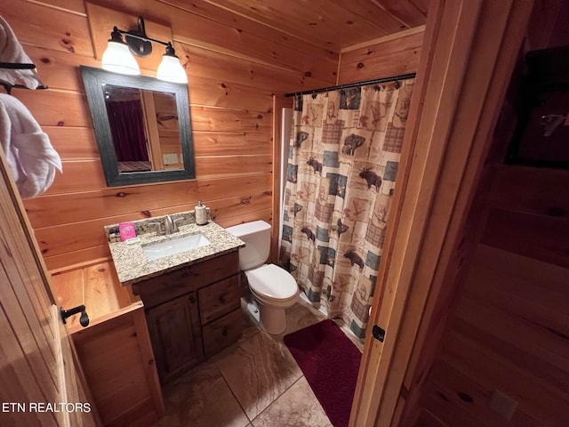 bathroom featuring wood walls, tile floors, toilet, and oversized vanity