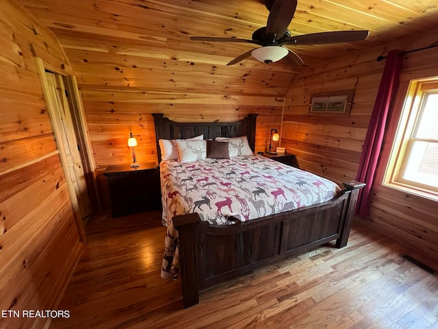 bedroom featuring ceiling fan, hardwood / wood-style flooring, wooden walls, and wood ceiling