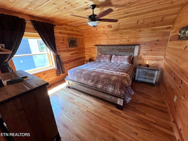 bedroom featuring lofted ceiling, hardwood / wood-style flooring, wooden walls, and wood ceiling