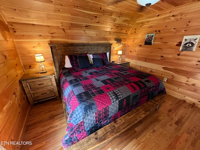 bedroom featuring wood-type flooring, wooden ceiling, wood walls, and vaulted ceiling