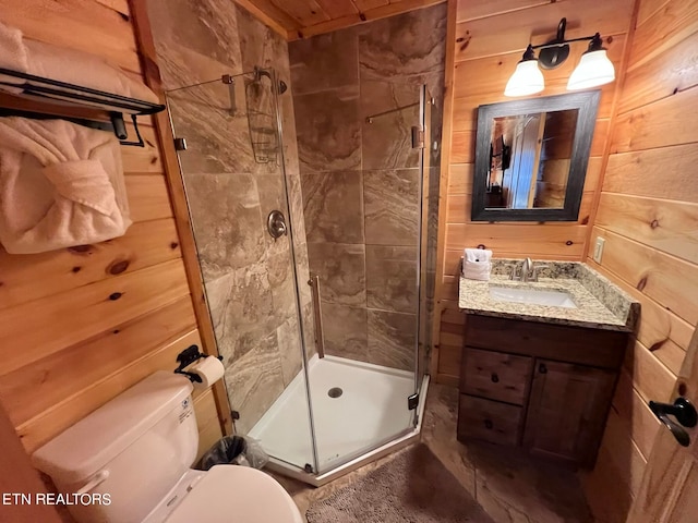 bathroom featuring vanity with extensive cabinet space, wood walls, an enclosed shower, and toilet