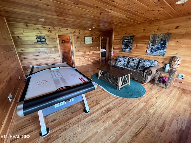 playroom with wood ceiling, wood walls, and light hardwood / wood-style flooring