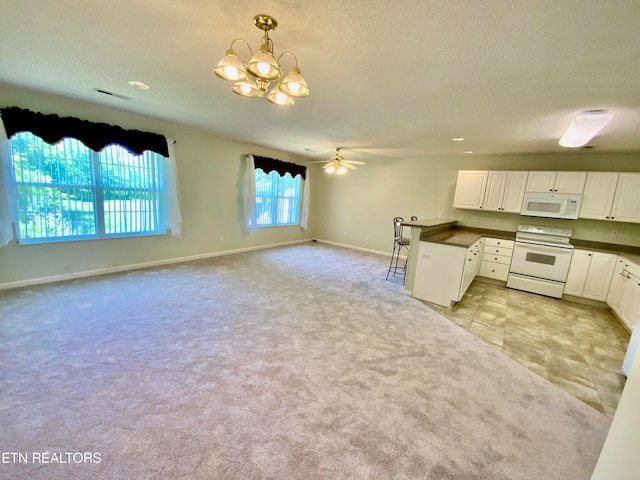 kitchen with pendant lighting, white appliances, white cabinetry, light colored carpet, and a textured ceiling