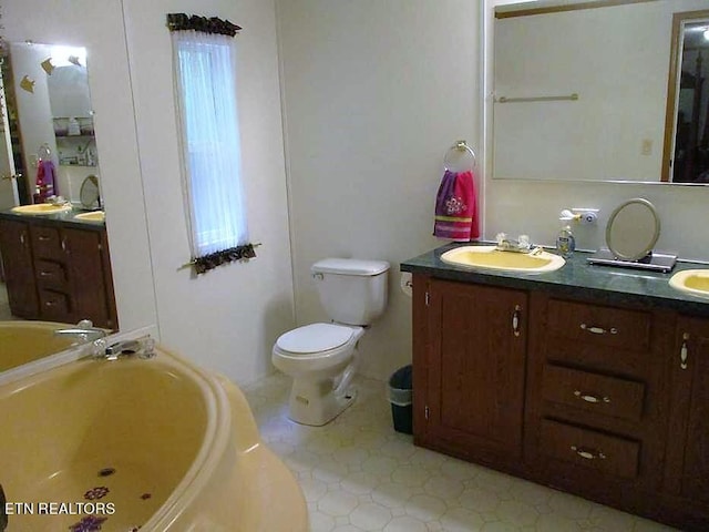 bathroom featuring a healthy amount of sunlight, dual bowl vanity, toilet, and tile flooring