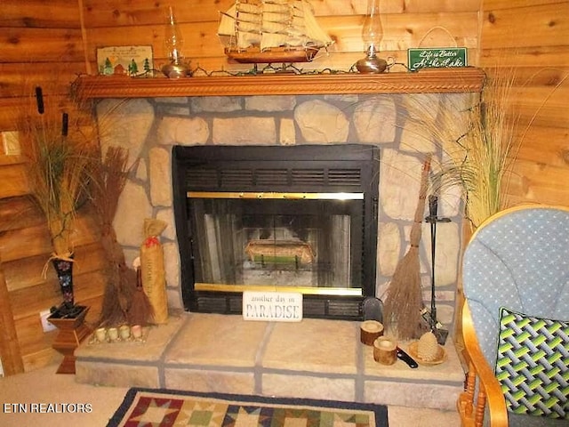 interior details featuring log walls and a stone fireplace