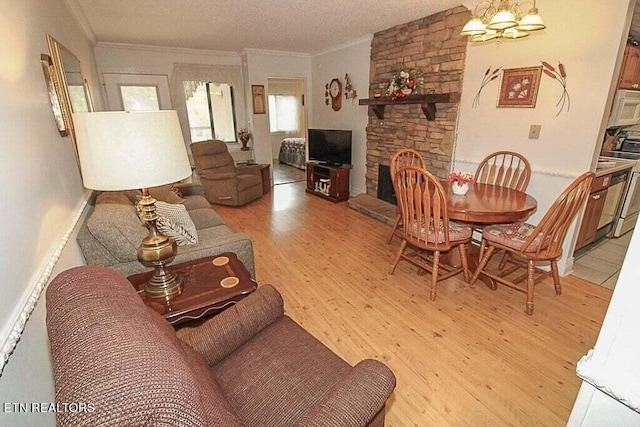 living room with a fireplace, a textured ceiling, a chandelier, ornamental molding, and light hardwood / wood-style flooring