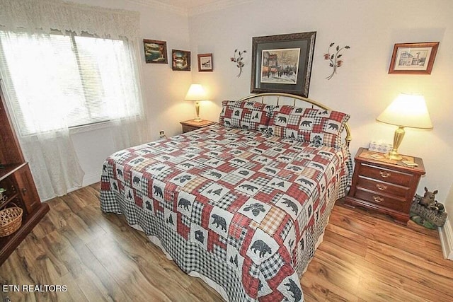 bedroom featuring wood-type flooring and ornamental molding