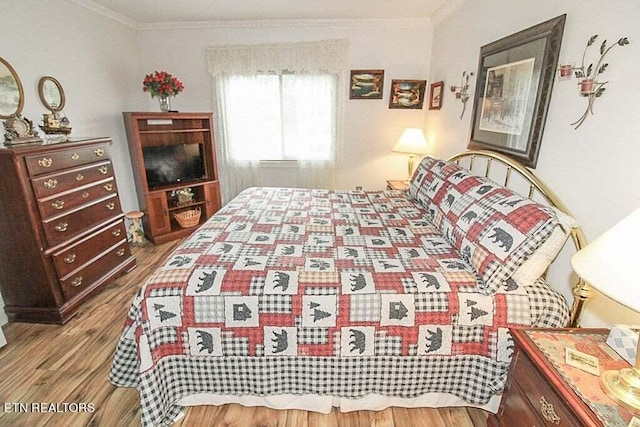 bedroom with hardwood / wood-style flooring and ornamental molding