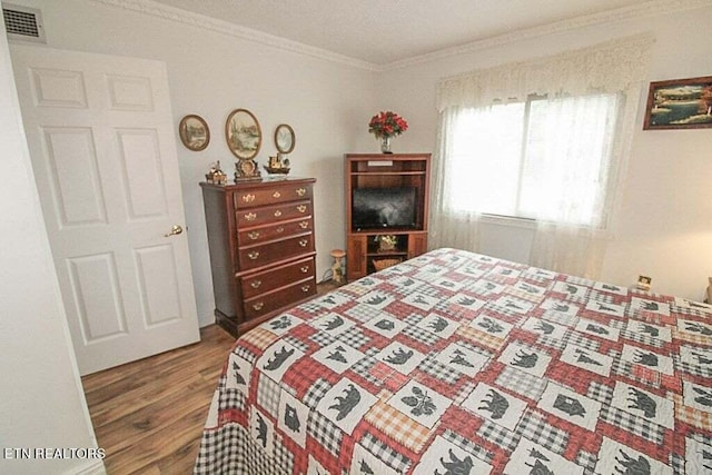 bedroom featuring ornamental molding and wood-type flooring