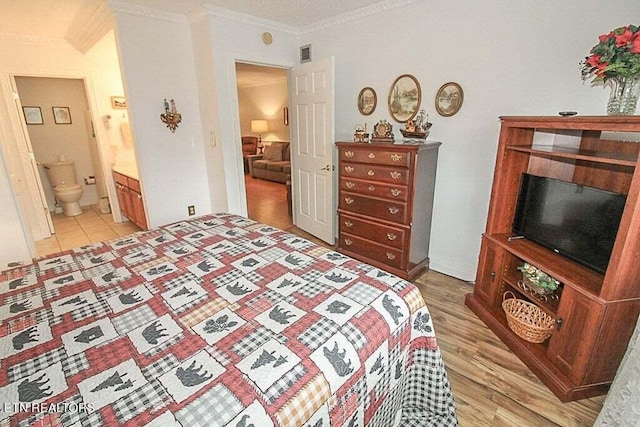 bedroom with ensuite bath, light hardwood / wood-style flooring, and ornamental molding