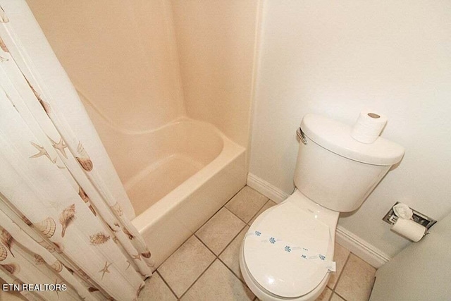 bathroom with tile flooring, toilet, and shower / bath combo with shower curtain