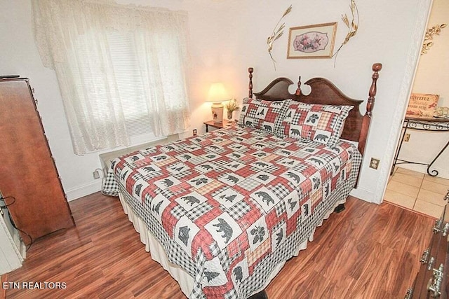 bedroom with dark hardwood / wood-style flooring