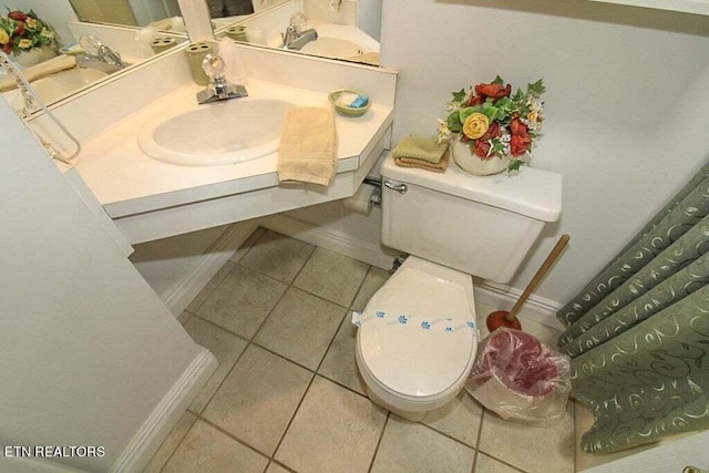 bathroom featuring tile flooring, vanity, and toilet