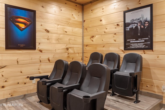 cinema room featuring wood-type flooring and wood walls