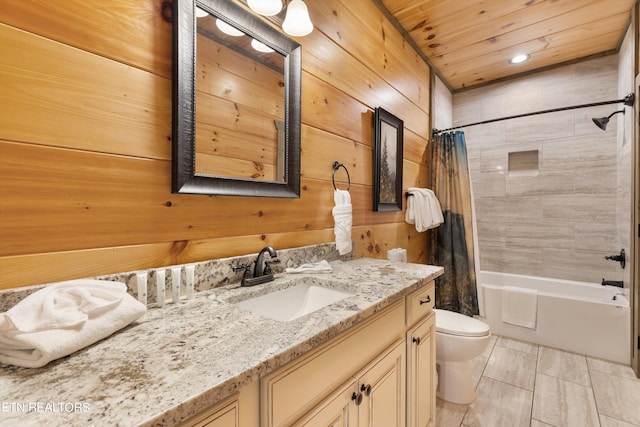 full bathroom with shower / bath combo with shower curtain, tile floors, wooden walls, vanity with extensive cabinet space, and toilet