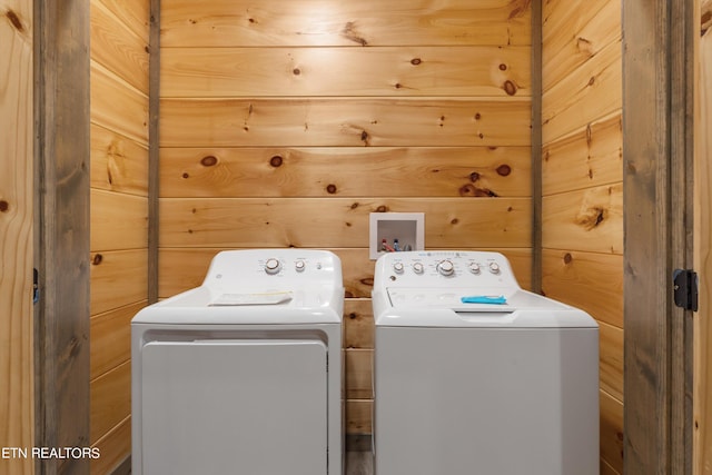 laundry area featuring independent washer and dryer, wooden walls, and hookup for a washing machine