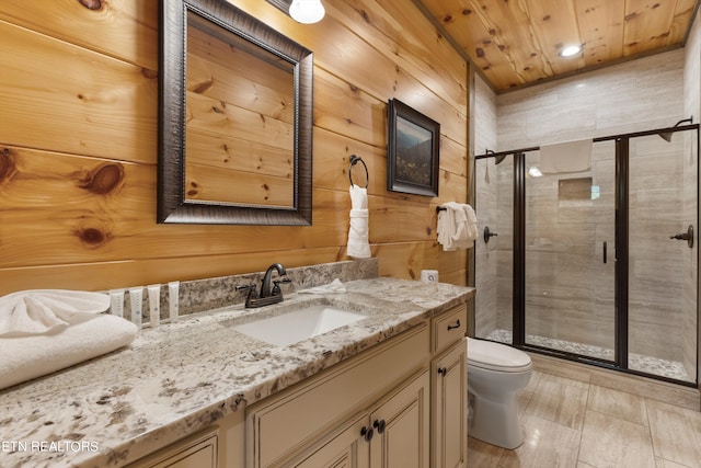 bathroom with a shower with shower door, wood walls, toilet, and vanity