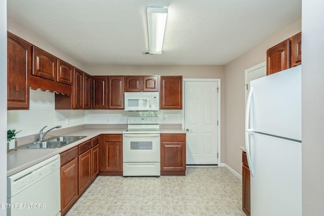 kitchen featuring light floors, a sink, white appliances, and light countertops
