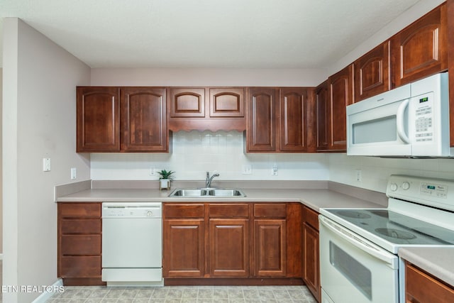 kitchen with light countertops, white appliances, a sink, and backsplash