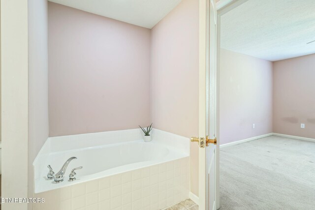 bathroom featuring a bath and baseboards