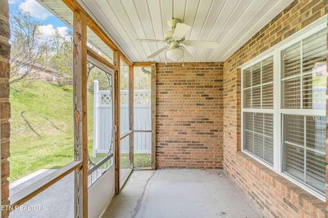 unfurnished sunroom with a wealth of natural light and a ceiling fan