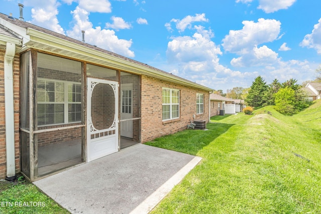 exterior space with a lawn, central AC unit, and brick siding