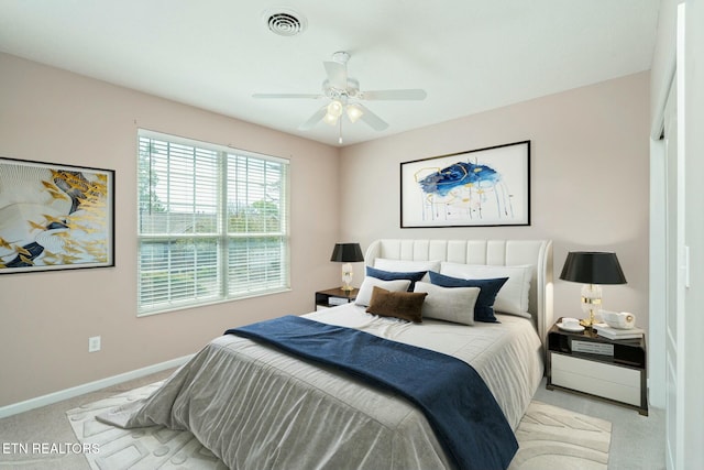 bedroom featuring light carpet, a ceiling fan, visible vents, and baseboards