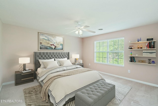 carpeted bedroom with visible vents, a ceiling fan, and baseboards
