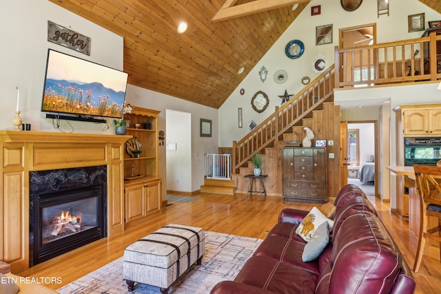 living room featuring high vaulted ceiling, a premium fireplace, and wooden ceiling