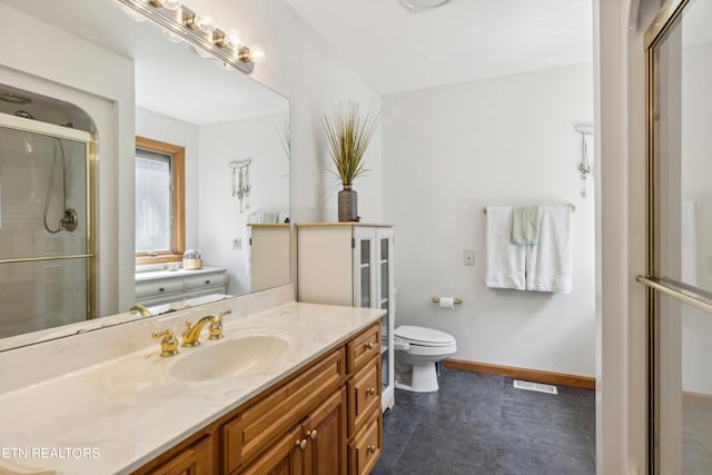 bathroom with tile floors, a shower with shower door, toilet, and large vanity