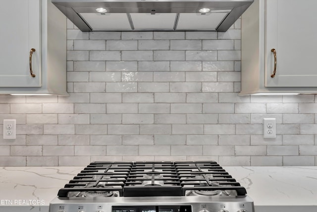 kitchen featuring ventilation hood, light stone counters, white cabinets, and stainless steel gas cooktop