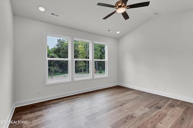 empty room with vaulted ceiling, hardwood / wood-style flooring, and ceiling fan