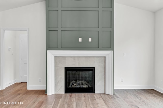 interior details featuring wood-type flooring and a tile fireplace