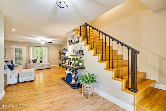 stairs with ceiling fan and hardwood / wood-style floors