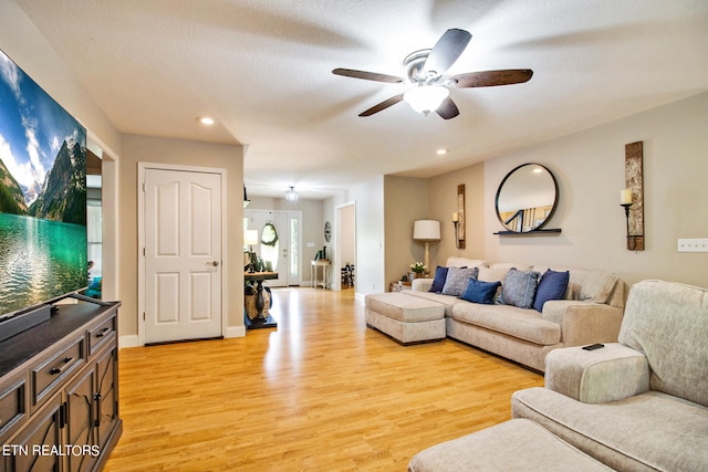 living room featuring light hardwood / wood-style floors and ceiling fan