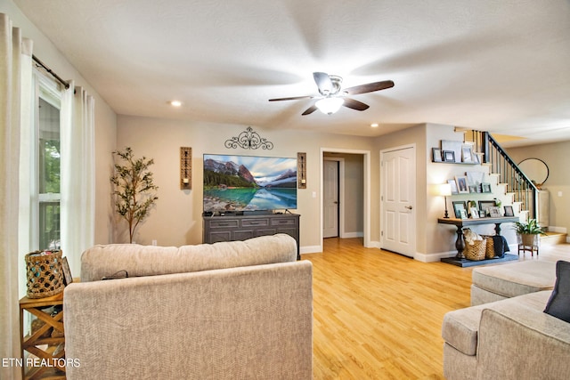 living room featuring ceiling fan and light hardwood / wood-style flooring